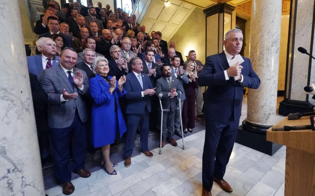Flanked by cheering and applauding Republican members of the House, Speaker Philip Gunn, R-Clinton, puts away his speaking points after presenting the House's position on their state income tax elimination legislation before reporters at the Mississippi Capitol in Jackson, Tuesday, March 15, 2022. (AP Photo/Rogelio V. Solis)