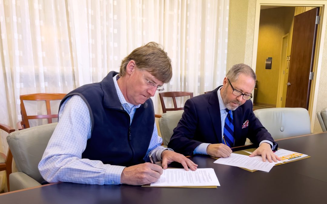 Vice President for Belhaven University Enrollment and Marketing Dr. Kevin Russell (left) and Greater Jackson Chamber Partnership President and CEO Jeff Rent (right) sign an agreement that will provide an enrollment scholarship to all GJCP members, employees and their children.