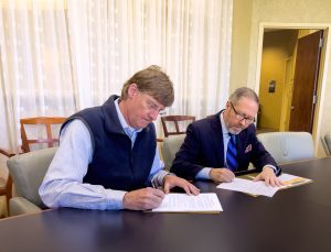 Vice President for Belhaven University Enrollment and Marketing Dr. Kevin Russell (left) and Greater Jackson Chamber Partnership President and CEO Jeff Rent (right) sign an agreement that will provide an enrollment scholarship to all GJCP members, employees and their children.