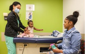 Nurse practitioner Ammy Davis, left, talks to Titanna Brown while screening Titanna's 9-month-old daughter, Nova Brown, at the Batson Kids Clinic in Jackson, Miss., Tuesday, April 18, 2023. Credit: Eric Shelton/Mississippi Today