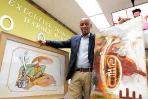 Harold Hart, owner of Elim's Art Concepts and Decorative Designs, with examples of framed artists' works, at his Jackson Medical Mall business, Thursday, May 4, 2023. Credit: Vickie D. King/Mississippi Today