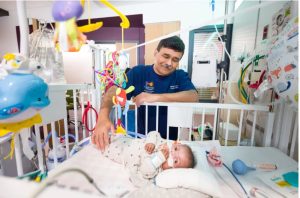 Dr. Bhatt, principal investigator of the Neonatal Research Network, visits Marian Johnson, a patient in the Sanderson Tower. Credit: Joe Ellis / UMMC Communications