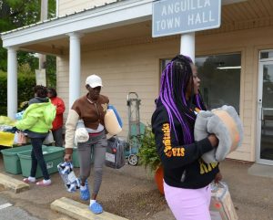 Anguilla residents Timiesha Gowdy (center) and Victoria Jackson (right), are currently residing in a hotel after a recent tornado devastated the area. Both women were at the Anguilla town hall seeking assistance, and were able to pick up a few items volunteers dropped off, Wednesday, March 29, 2023.