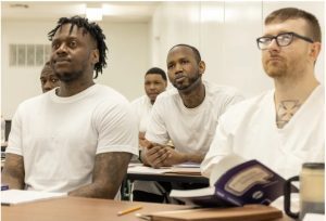Carlos White, left, watches as a fellow student gives his speech.