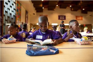 Landen Maddox reads a book after breakfast on the first of school at Clarksdale Collegiate Public Charter School Wednesday, July 25, 2018. Clarksdale Collegiate is the state’s first rural charter school. Credit: Eric J. Shelton, Mississippi Today/ Report for America