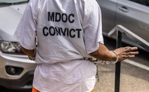 A woman going through the civil commitment process, wearing a shirt labeling her a “convict,” is transported from her commitment hearing back to a county jail to await transportation to a state hospital in north Mississippi this spring.