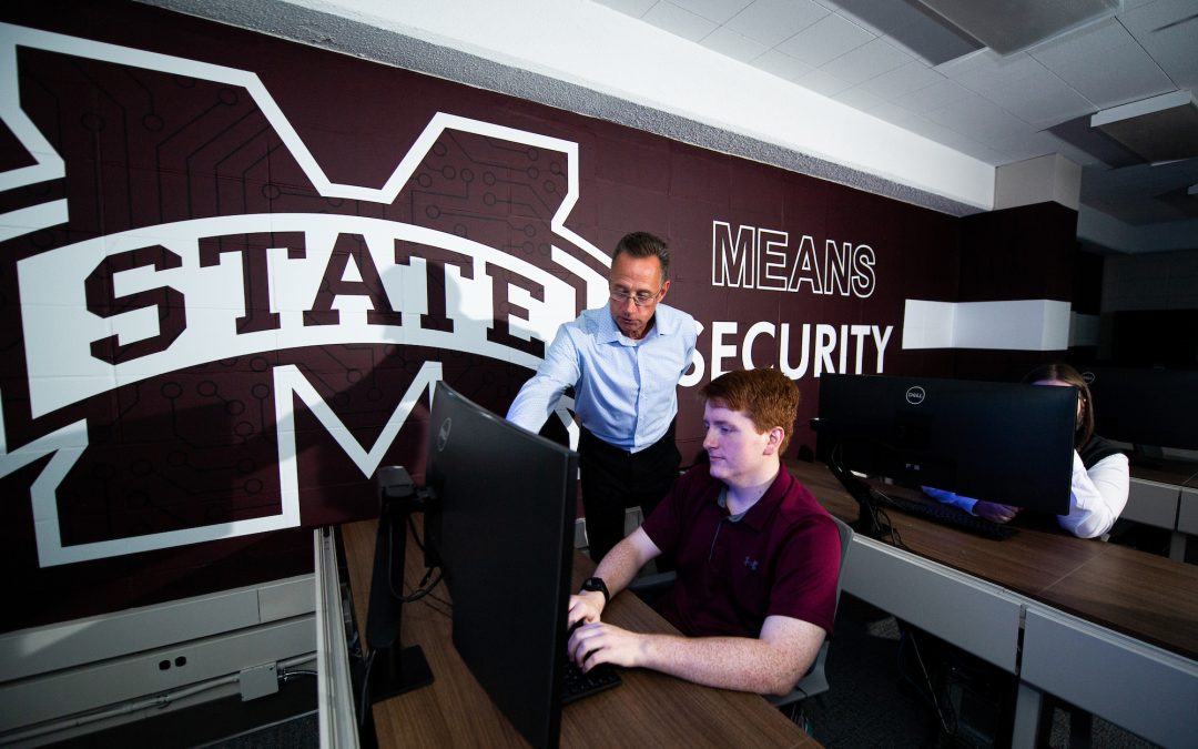 Associate Clinical Professor George Trawick, MSU cybersecurity program coordinator, looks on as computer science major Matthew Morgan of Hattiesburg works in Butler Hall's cybersecurity lab. (Photo by Grace Cockrell)