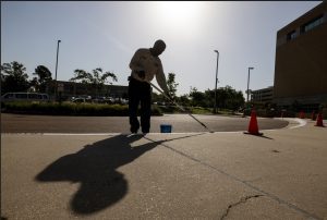 UMMC employee Palmer Christian paints early Tuesday morning to avoid dangerous heat later in the day.