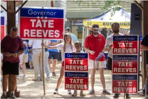 Gov. Tate Reeves supporters hold political signs during the 2023 Neshoba County Fair in Philadelphia, Miss., Thursday, July 27, 2023. Credit: Eric Shelton/Mississippi Today
