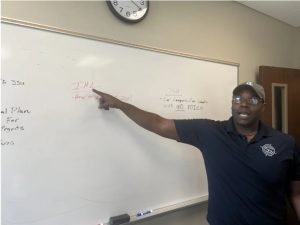 Shelton Pittman uses a whiteboard to deconstruct his thoughts on IHL's presidential search process on Oct. 9 while trustees are in executive session. Credit: Molly Minta/Mississippi Today