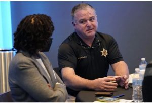 Rankin County Sheriff Bryan Bailey, right, speaks to an attendee at an employer engagement forum in Jackson, Miss., Nov. 4, 2021. Bailey announced Tuesday, June 27, 2023, that an unspecified number of Rankin County deputies had been fired because of their involvement in a Jan. 24, encounter in which two Black men said six white deputies handcuffed and beat them and one of the Black men was shot in the mouth. Credit: Photo/Rogelio V. Solis, File)