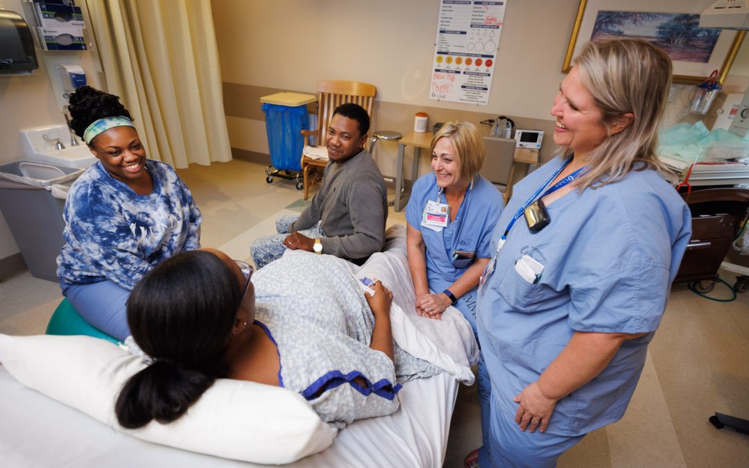 From left, UMMC Labor and Delivery Registered Nurse Ty Sims and Certified Nurse-Midwives Janice Scaggs and Kim Rickard provide care for Danielle Aguillard as she and her husband, Cortrel Horton, prepare for the birth of their son.