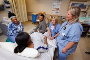 From left, UMMC Labor and Delivery Registered Nurse Ty Sims and Certified Nurse-Midwives Janice Scaggs and Kim Rickard provide care for Danielle Aguillard as she and her husband, Cortrel Horton, prepare for the birth of their son.