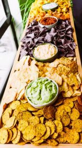 A fun New Year's Eve gathering idea is to create a charcuterie board filled with a variety of dips, chips and crackers. 