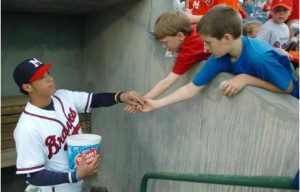 Mississippi Braves' Gregor Blanco, left, shares some of the team's "professional-grade" bubble gum with youngsters before the team's home opener against the Montgomery Biscuits, Monday, April 18, 2005, at Trustmark Park in Pearl, Miss. (AP Photo/Rogelio Solis)
