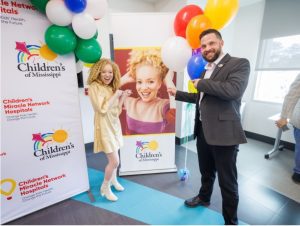 Ava Clarke smiles by her banner with Northwest Rankin Principal Lewis Bradford.