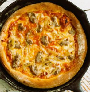 Homemade pizza made in a skillet contains the perfect crispy crust and perfectly-cooked toppings.