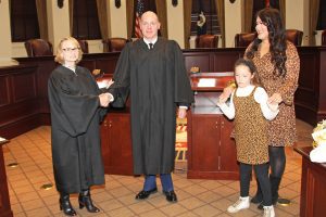 Col. Nick Saucier, center, shakes hands with Mississippi Court of Appeals Presiding Judge Virginia Carlton after taking the oath of office as State Military Judge on March 1. At right are his wife Bonny Saucier and daughter Livi.