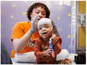 Anderson finishes preparing True for an EEG at the Comprehensive Epilepsy Center at Children's of Mississippi.
