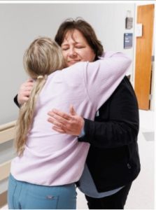 Farris hugs Kaitlin Chesser, a registered nurse in the Bone Marrow Transplant Unit.