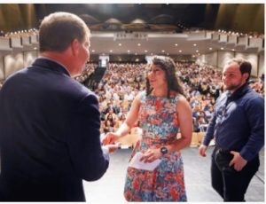 Medical student Erica Rubio is congratulated by Dr. Mike McMullan, associate dean for student affairs at UMMC, as her fiance Jacob Cole Floyd looks on.