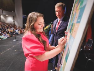 Addie Hitt, who matched in internal medicine-pediatrics at UMMC, places a pin in a map of the state during Match Day.