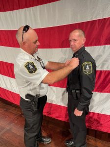 Mississippi State Hospital Police Chief, Jeff Luckey, pins law enforcement badge to Officer Charles Shows' uniform after the MLEOTA graduation on March 21, 2024.