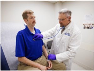Dr. Pawel Pomianowski, medical director of the newly-established Division of Genetics and Genomics, listens to Brian McDade's heart.
