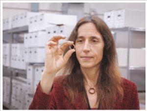 Dr. Jennifer Mack, lead bioarchaeologist for the Asylum Hill Project, displays the gold wedding ring her late husband, Dustin Clarke, discovered. It is inscribed with the words "Ever true to thee." On a string around her neck is the wooden wedding band that belonged to her husband.