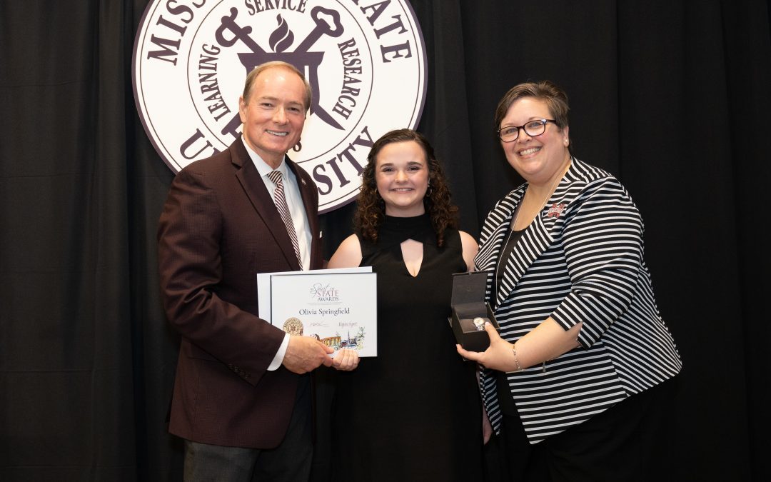 Olivia Springfield, center, receives the Spirit of State Award from MSU President Mark E. Keenum and Vice President for Student Affairs Regina Hyatt. (Photo by Jonah Holland)
