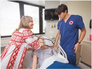 Dr. Amanda Weeks, director of simulation, assists nursing Barberi in health assessment.