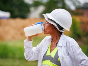 Lead Bioarchaeologist Dr. Jennifer Mack pauses for a drink of water while working at the Asylum Hill Project site on campus. Mack's team and others braving the elements this week will experience "feel like" temperatures well over 100 degrees.