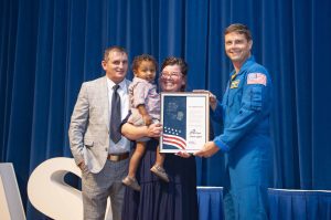 : NASA’s Stennis Space Center employee Tessa Keating, a native and resident of Carriere, Mississippi, receives the prestigious Space Flight Awareness Silver Snoopy award from NASA astronaut Reid Wiseman during the Aug. 21 ceremony. She is accompanied by her husband, Roy, and son, Knox. Photo Credit: NASA/Danny Nowlin