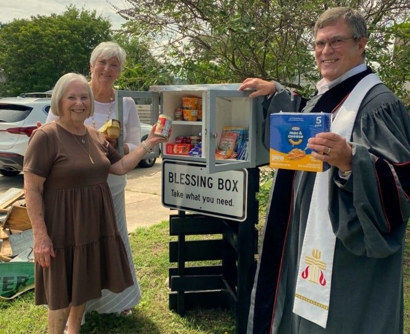 Reverend Gillespie helps Elder Amy Egolf and Congregant Kay Bodamer stock the Old Town Presbyterian Church Blessing Box with non-perishable items to help area families in need of food.