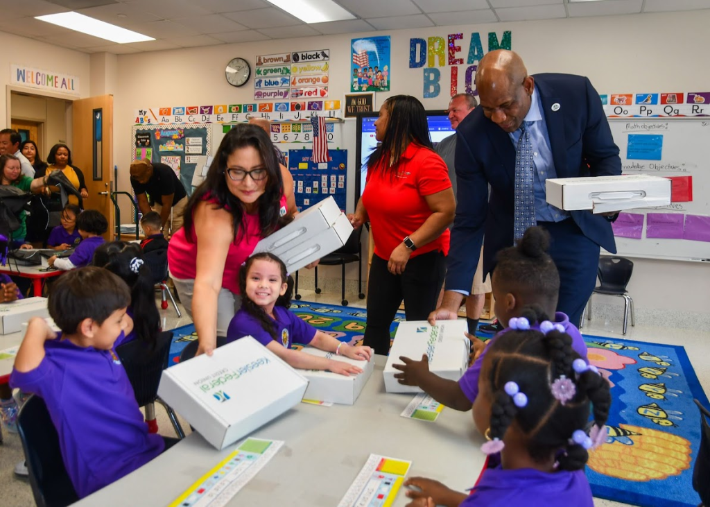 Keesler Federal Credit Union's Community Development Officer Rebecca Hernandez (left) hands out school supplies to kindergarteners at Terrytown Elementary School in Louisiana's Jefferson Parish School District.