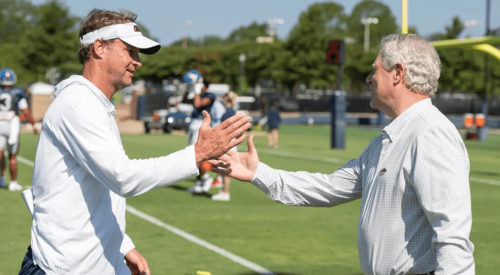 hancellor Glenn Boyce (right) greets coach Lane Kiffin at an Ole Miss football practice. Boyce has been named to a two-year term on the NCAA Board of Governors and a four year-term on the board of directors. (Photo by Thomas Graning/Ole Miss Digital Imaging Services)