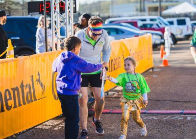 PICU nurse manager Gordan Gartell, a 5K walker, watches daughter Eleanor get a medal after the Kids' Fun Run.