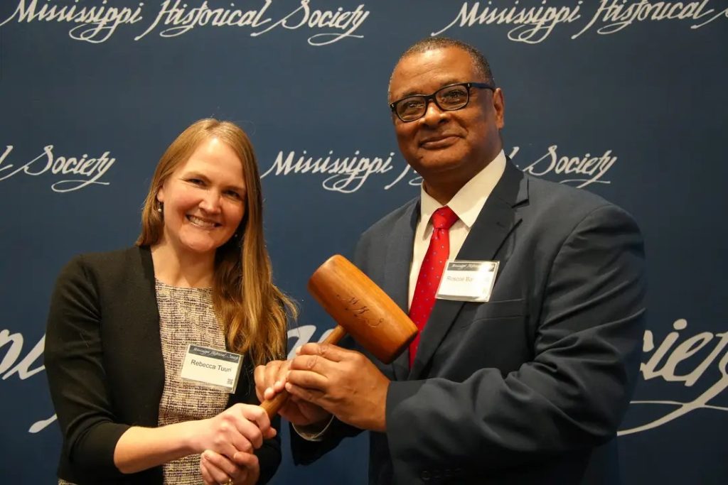 Dr. Rebecca Tuuri, the outgoing president of the Mississippi Historical Society, passes the gavel to Dr. Roscoe Barnes III, who will lead the organization for the next year through March 5, 2026.