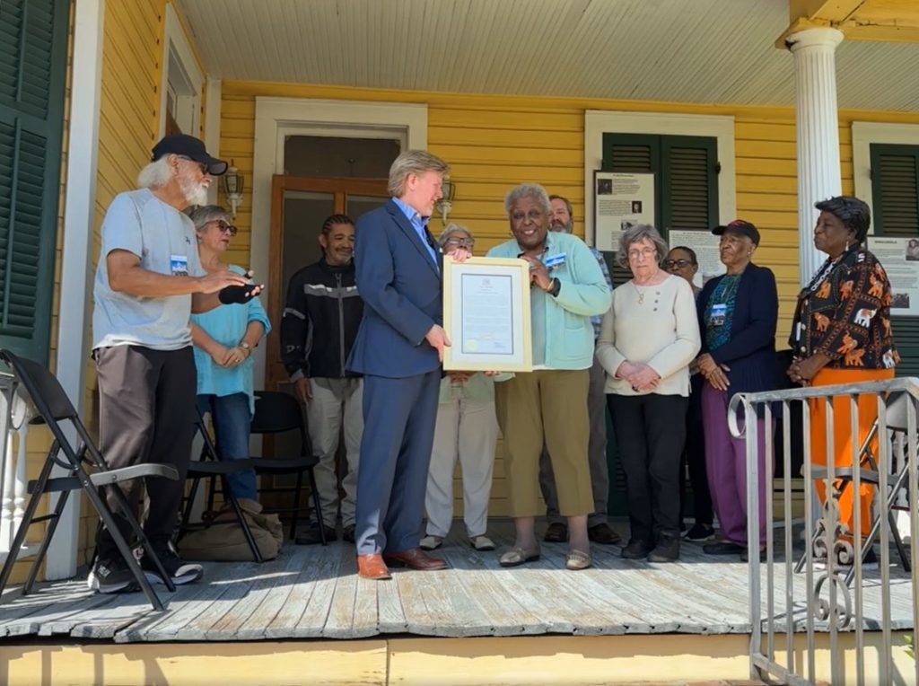 Mayor Dan Gibson recently honored Dr. John Bowman Banks posthumously with a Key to the City, which he presented to Dora Hawkins, a staff member of the Dr. John Bowman Banks Museum. From left are Willie Woods, Kathleen Bonds, Bobby Dennis, Alderwoman Valencia Hall, Richard Burke, Mimi Miller, Sheryl Woods, Jacqulyn Williams, and Thelma Newsome.