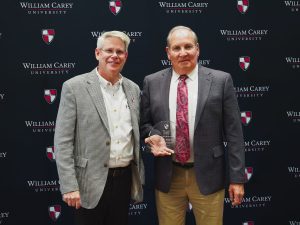 William Carey University President Ben Burnett, left, welcomes Bobby Halford into the WCU Alumni Hall of Fame.