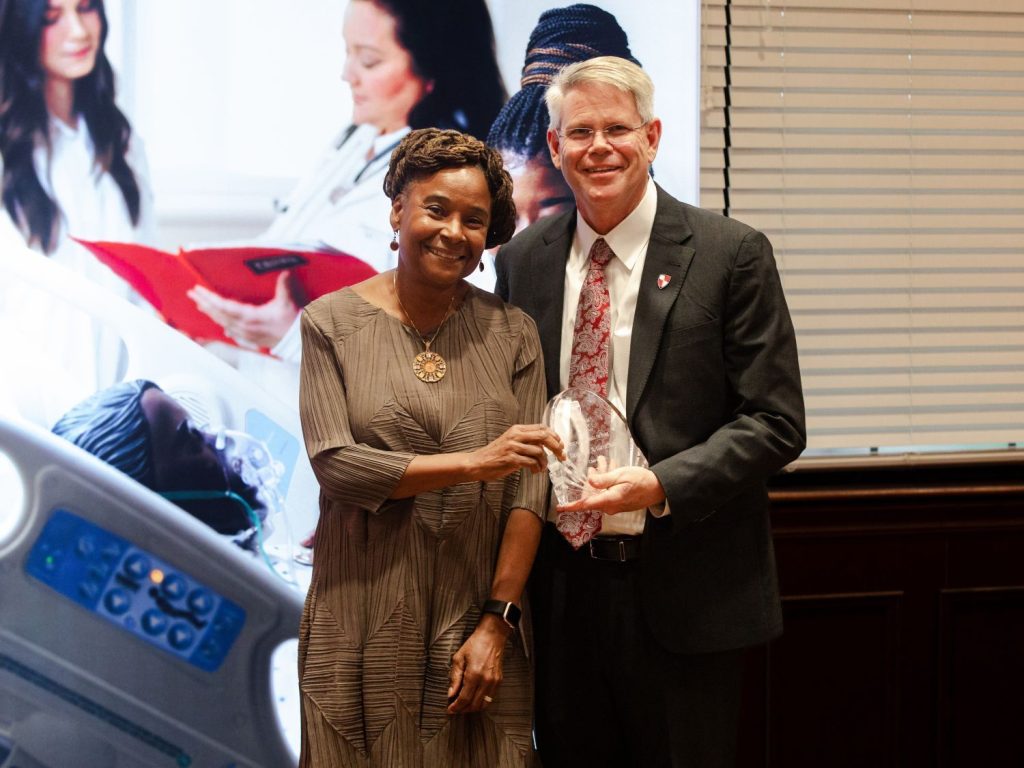 William Carey University President Ben Burnett, right, welcomes Tracy Cook into the WCU Alumni Hall of Fame.
