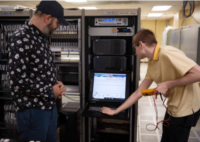 NASA engineers Steven Helmstetter, left, and Tristan Mooney work with the NASA Data Acquisition System in the E-1 Test Control Center, where the system is utilized for propulsion test activities. (Photo Credit: NASA/Danny Nowlin)