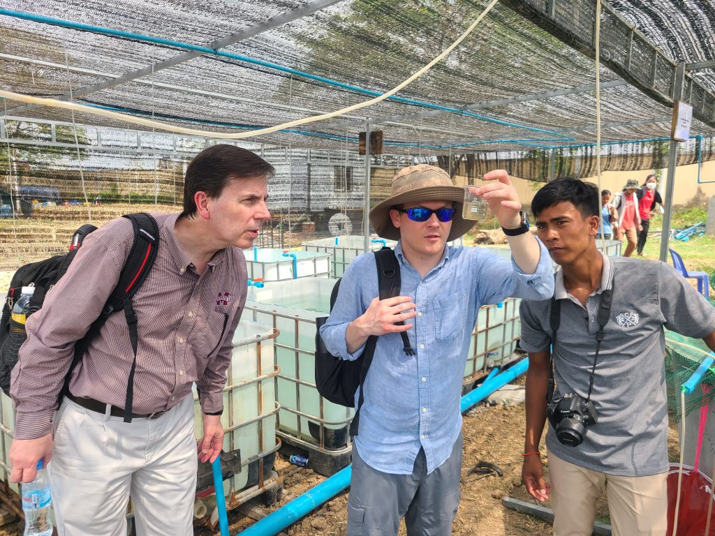 From left, Global Center for Aquatic Health and Food Security Director Mark Lawrence, GCAHFS Associate Director Stephen Reichley and a local partner in Cambodia look at a water sample. GCAHFS international work developing sustainable aquatic food systems is being recognized as part of the U.N. Food and Agriculture Organization’s 80th anniversary celebrations this week. (Photo submitted)