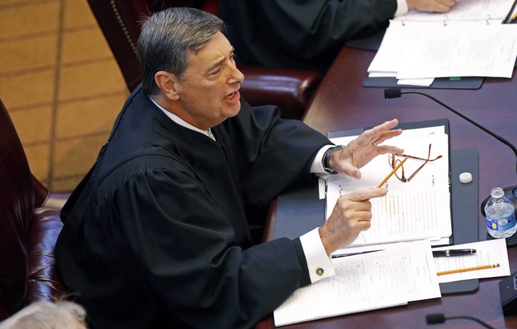 U.S. District Court Chief Judge Louis Guirola, Jr., of the Southern District of Mississippi, questions the student law school advocates during a moot court competition between the state's two law schools, Mississippi College School of Law and the University of Mississippi School of Law in Jackson, Miss., Wednesday, Sept. 27, 2017. (AP Photo/Rogelio V. Solis)