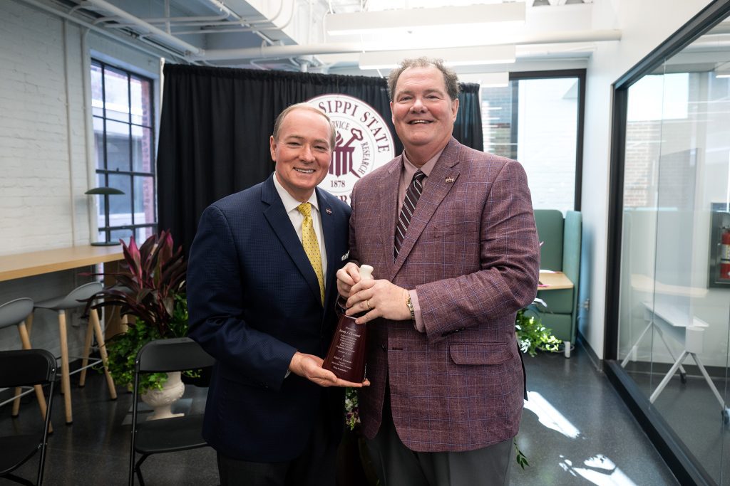 MSU President Mark E. Keenum, left, presents a cowbell to Randy Cleveland on the occasion of today’s [Nov. 18] ribbon-cutting ceremony for the university’s Randy J. Cleveland Engineering Student Center. Keenum expressed appreciation for Cleveland, noting that the 2022 National Alumnus of the Year exemplifies the characteristics of integrity, hard work and respect for others. (Photo by Emily Grace McCall)