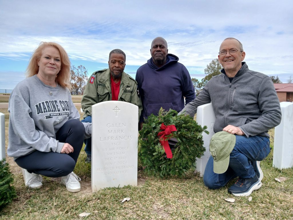 In December 2024, volunteers with the Home with Heroes honored the late G. Mark LaFrancis, the organization’s founder, as they laid a wreath on his grave at the Natchez National Cemetery. Pictured from left are military veterans Gabi Crousillac, Robert Pernell, Ben Tucker, and Larry Smith. The event was part of the Wreaths Across America campaign.