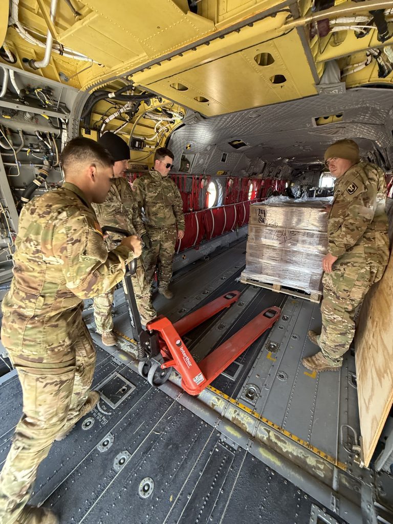 Soldiers from the 185th Aviation Brigade load pallets of water, cots, and Meals, Ready-toEat (MREs) aboard a CH-47 Chinook helicopter in preparation for departure to Corinth, Mississippi, supporting ongoing emergency response operations, Jan. 27, 2026. (U.S. Army National Guard photo by Maj. Kandi Murphy)