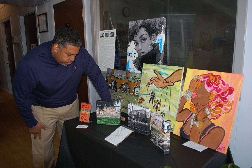 In this file photo, Malcolm Innis, owner of New Vision Media, reviews an exhibit of African American art on display during Black History Month 2024 in the lobby of WTYJ/WMIS at 20 E. Franklin St. Photo by Roscoe Barnes III