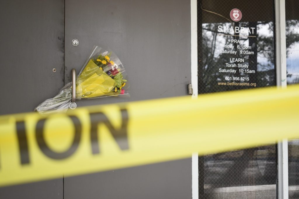 Caution tape and flowers cover the entrance to the Beth Israel Congregation, a synagogue that was set on fire early Saturday morning, on Monday, Jan. 12, 2026, in Jackson, Miss. (AP Photo/Sophie Bates)