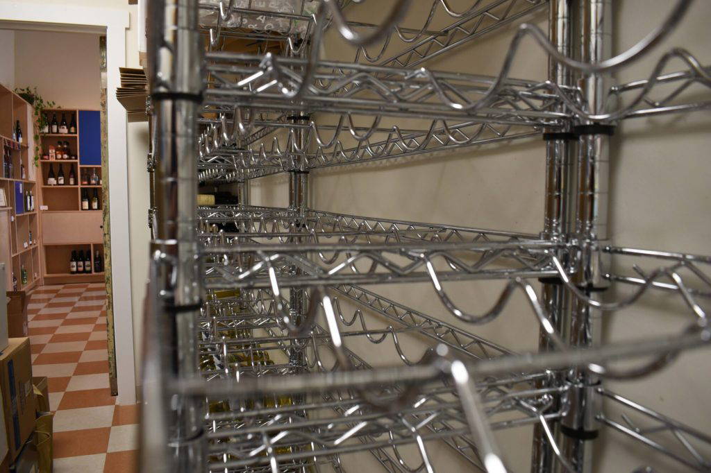 A backroom wine rack sits empty at the Levure Bottle Shop in Jackson, Miss., on Wednesday, April 15, 2026. (AP Photo/Sophie Bates)